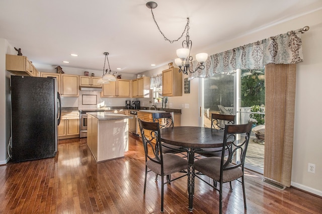 dining space featuring a notable chandelier, dark hardwood / wood-style flooring, and sink