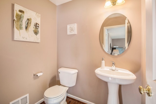 bathroom with wood-type flooring and toilet