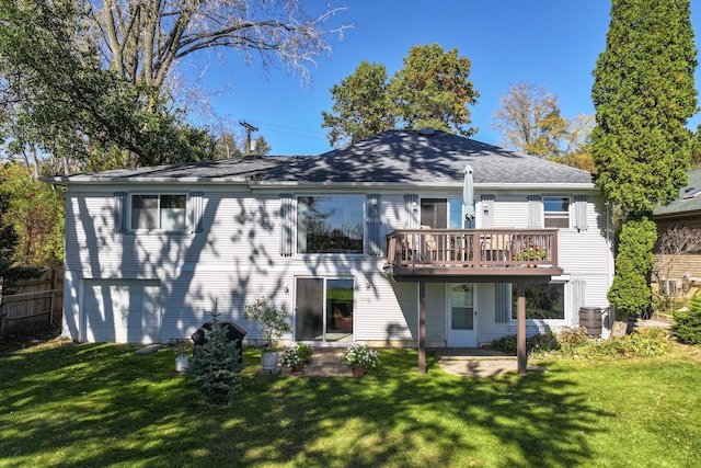 rear view of house featuring a yard, a garage, and a deck