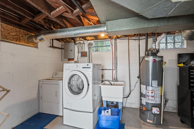 washroom with electric panel, a wealth of natural light, washer and clothes dryer, and gas water heater