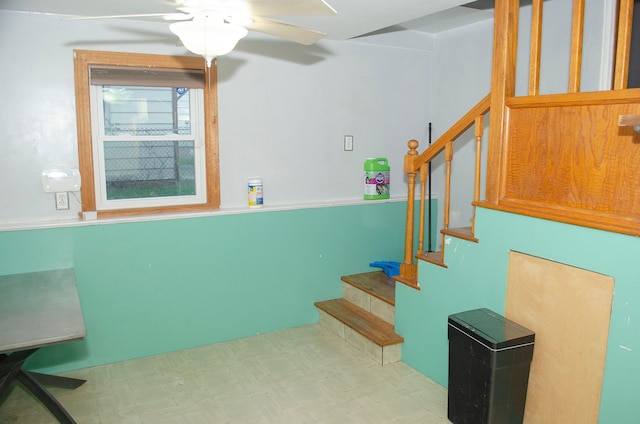 staircase featuring ceiling fan