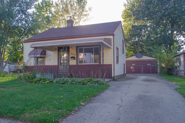 bungalow-style house with a garage, an outbuilding, and a front yard