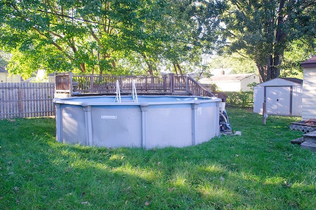 view of pool with a yard, a deck, and a storage shed