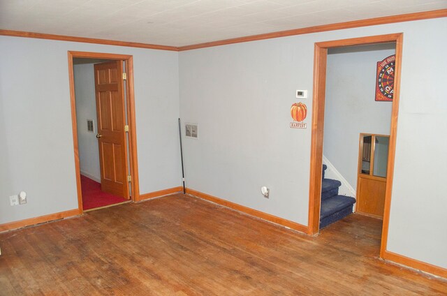 unfurnished room with hardwood / wood-style flooring and ornamental molding