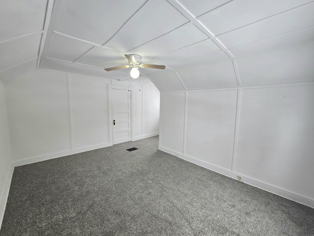 additional living space with ceiling fan, lofted ceiling, and dark colored carpet