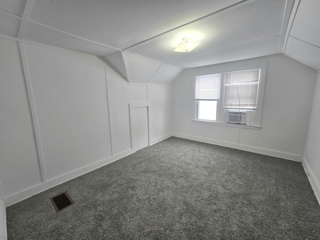 additional living space featuring vaulted ceiling, dark carpet, and cooling unit