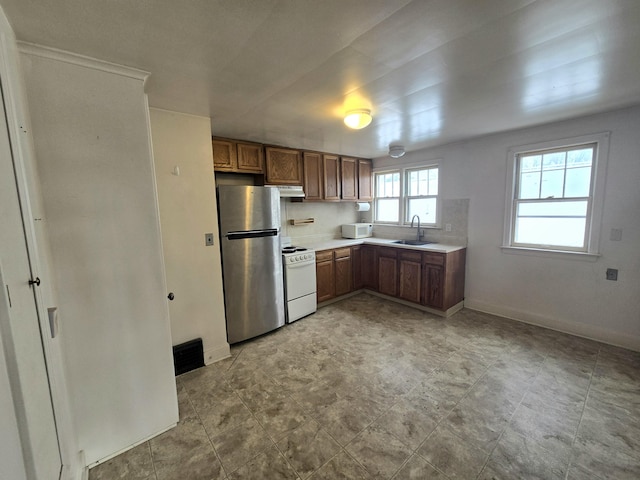 kitchen with decorative backsplash, sink, and white appliances