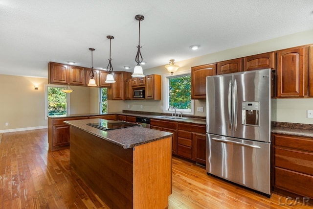 kitchen with a kitchen island, sink, stainless steel appliances, and light hardwood / wood-style flooring