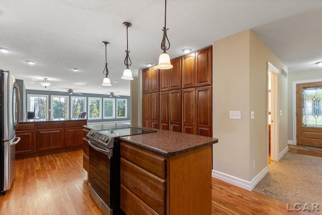 kitchen with a center island, stainless steel appliances, plenty of natural light, and light wood-type flooring