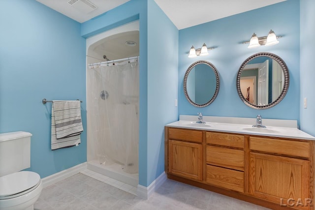 bathroom with a shower with curtain, vanity, toilet, and tile patterned floors