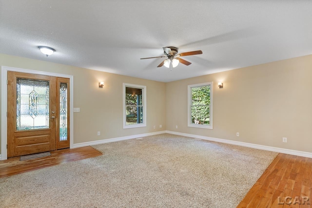 foyer featuring hardwood / wood-style flooring, ceiling fan, and a textured ceiling