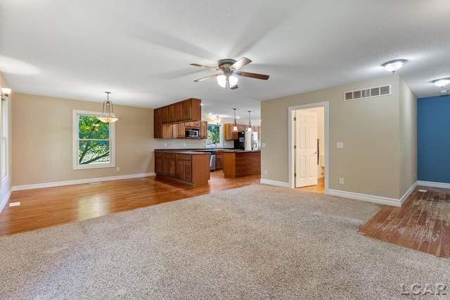 kitchen featuring pendant lighting, stainless steel appliances, light hardwood / wood-style flooring, and ceiling fan