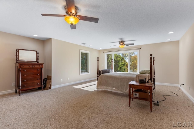 carpeted bedroom featuring ceiling fan and a textured ceiling