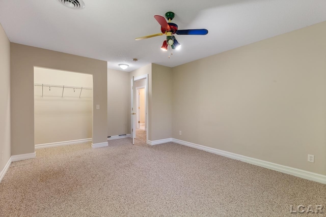 unfurnished bedroom with carpet flooring, rail lighting, a closet, and ceiling fan