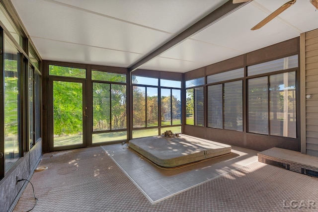 unfurnished sunroom featuring ceiling fan