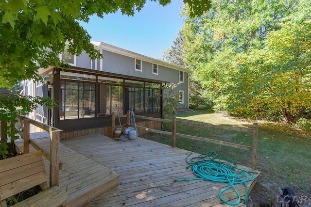 deck featuring a sunroom and a yard