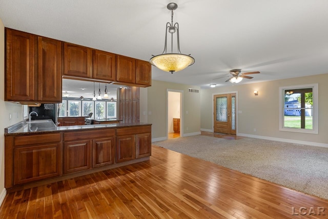 kitchen featuring a wealth of natural light, hardwood / wood-style floors, ceiling fan, and decorative light fixtures