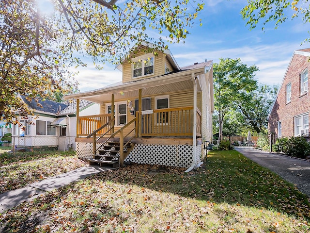 view of front of home with covered porch and a front lawn