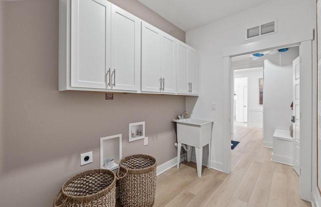 clothes washing area featuring hookup for an electric dryer, cabinets, light wood-type flooring, and hookup for a washing machine