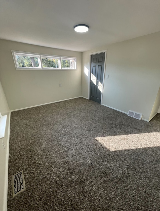 empty room with dark colored carpet