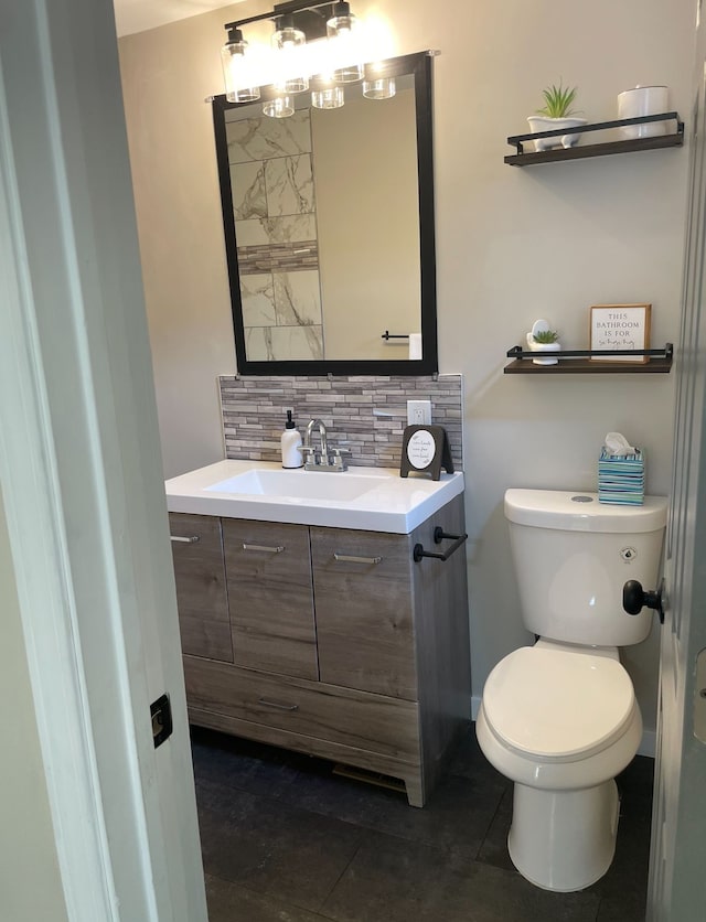 bathroom featuring tasteful backsplash, vanity, tile patterned floors, and toilet