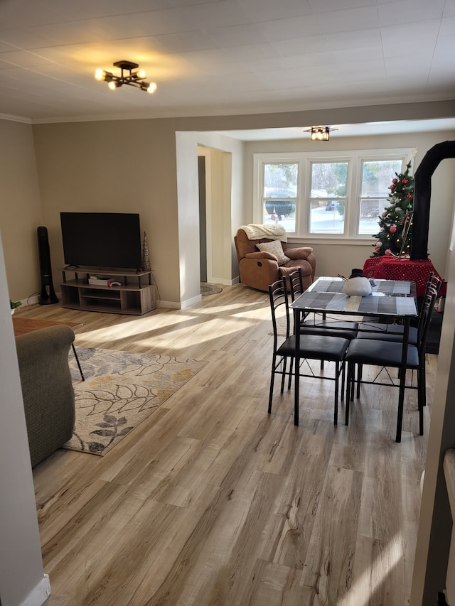 dining space featuring hardwood / wood-style flooring, ornamental molding, and an inviting chandelier