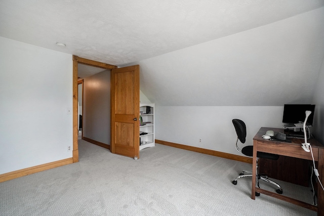 carpeted home office featuring a textured ceiling and lofted ceiling