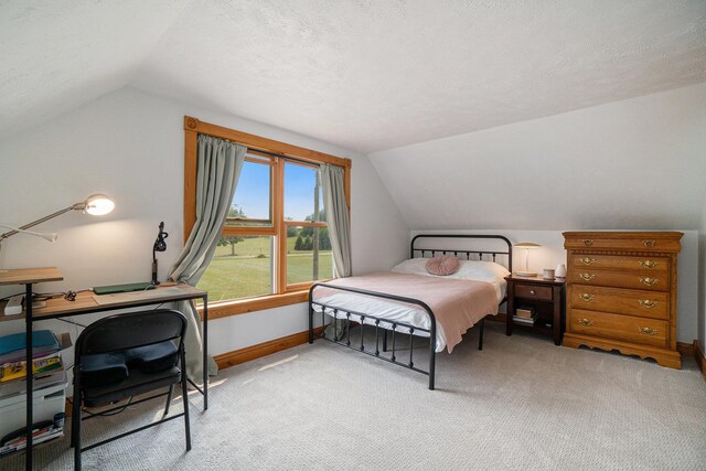 carpeted bedroom featuring lofted ceiling and a textured ceiling