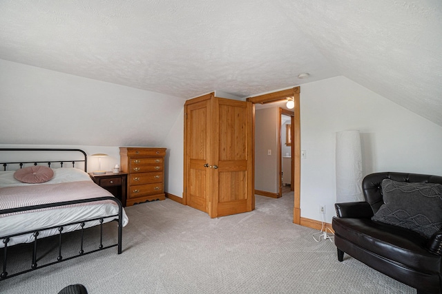 carpeted bedroom featuring a textured ceiling and vaulted ceiling