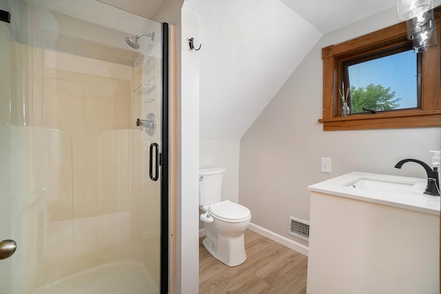 bathroom featuring hardwood / wood-style floors, vanity, lofted ceiling, toilet, and a shower with shower door