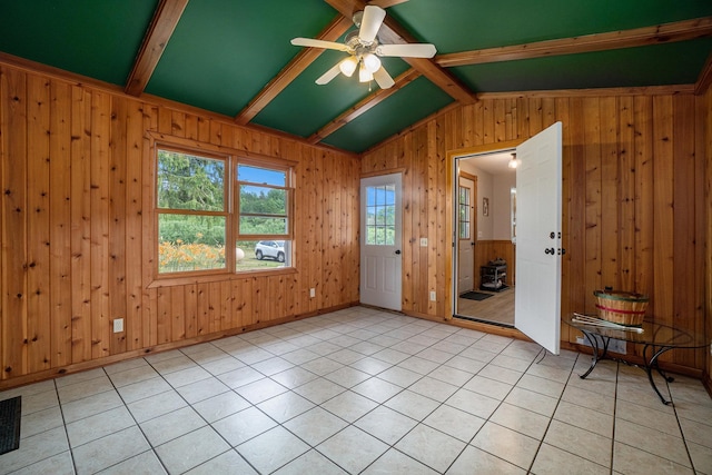 tiled empty room featuring lofted ceiling with beams, ceiling fan, and wooden walls