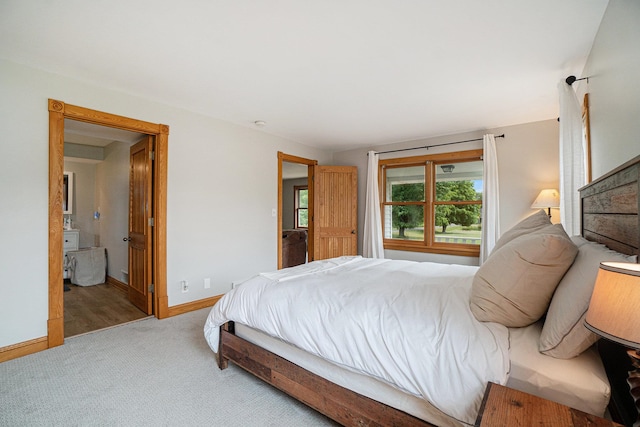 bedroom featuring light carpet and connected bathroom