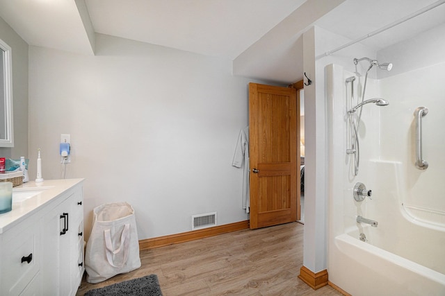 bathroom with hardwood / wood-style flooring, vanity, and shower / bath combination