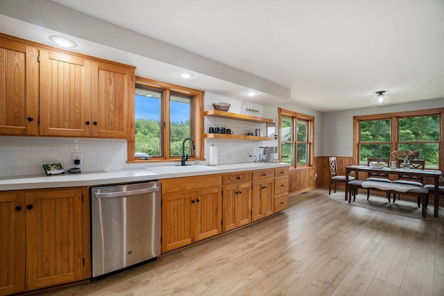 kitchen with a healthy amount of sunlight, sink, stainless steel dishwasher, and light wood-type flooring