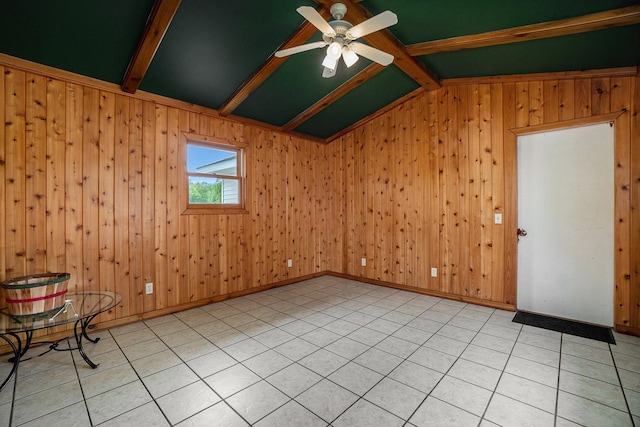 tiled empty room with lofted ceiling with beams, ceiling fan, and wood walls