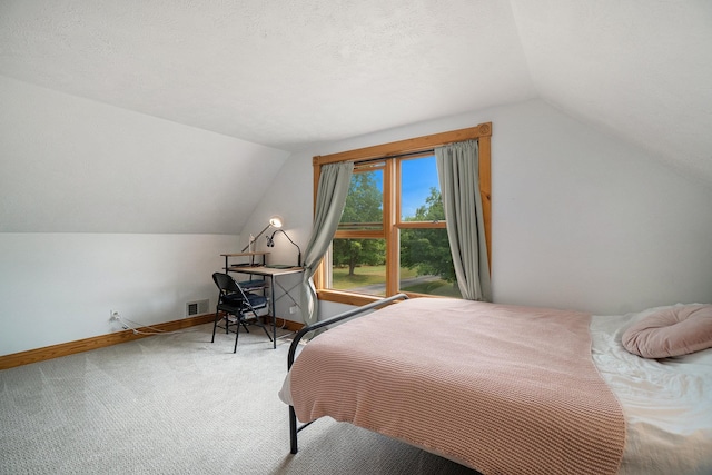 carpeted bedroom with a textured ceiling and vaulted ceiling