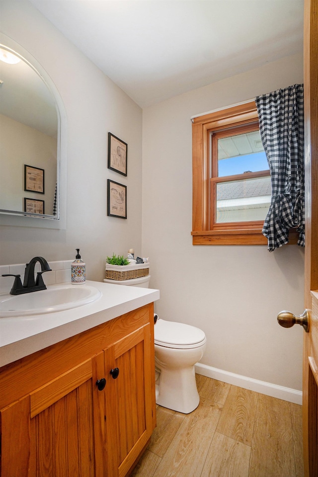 bathroom featuring vanity, toilet, and wood-type flooring