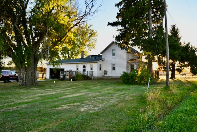 back of property featuring a yard and a garage