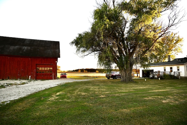 view of yard featuring driveway, an outbuilding, a barn, and a detached garage