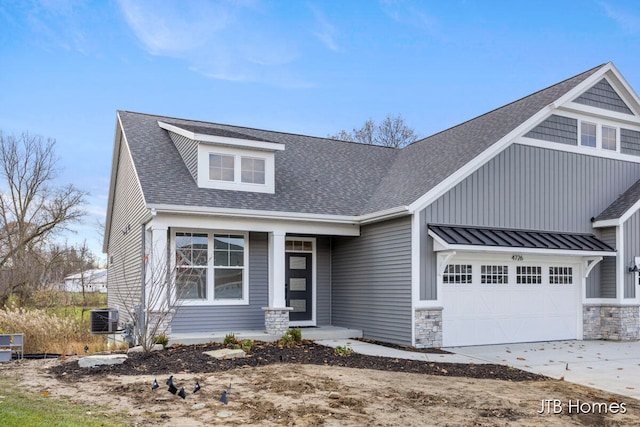 view of front of property featuring a garage and cooling unit