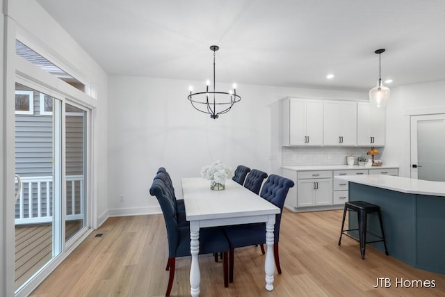 dining space featuring an inviting chandelier and light hardwood / wood-style flooring