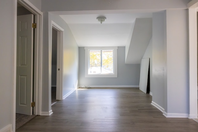 bonus room with dark hardwood / wood-style flooring and vaulted ceiling