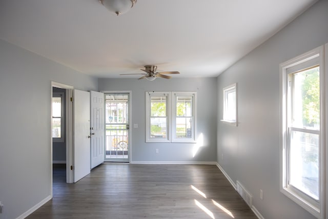 unfurnished room with plenty of natural light, dark hardwood / wood-style floors, and ceiling fan