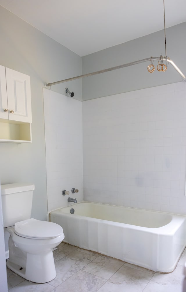 bathroom featuring tiled shower / bath combo and toilet