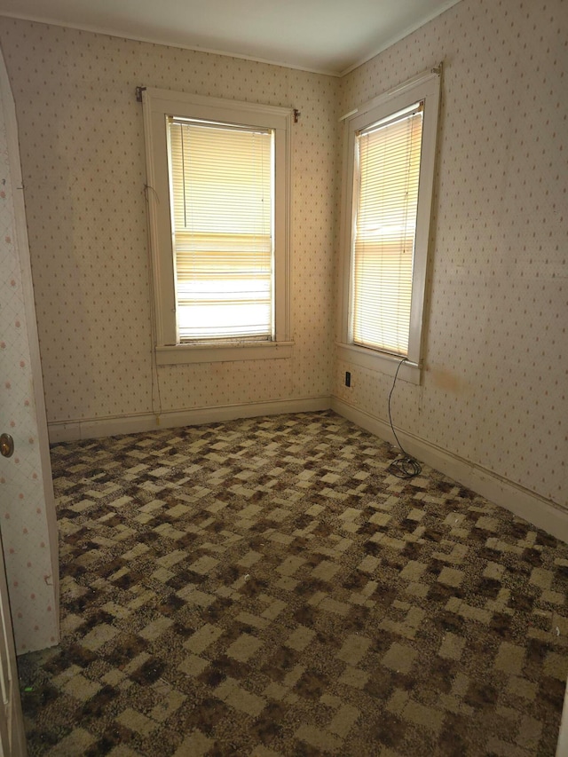 empty room with dark colored carpet and crown molding