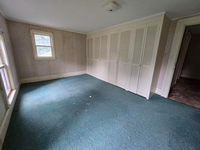 unfurnished bedroom featuring crown molding and dark carpet