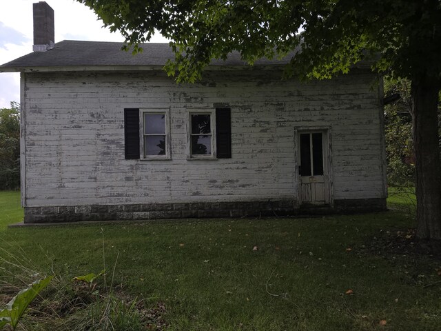103 S Railroad St, Allen, MI 49227 - view of property exterior with a chimney, a yard, and brick siding
