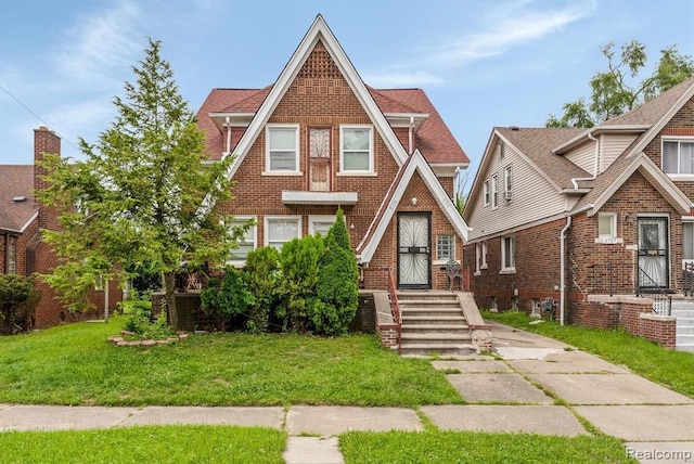 tudor home featuring a front lawn