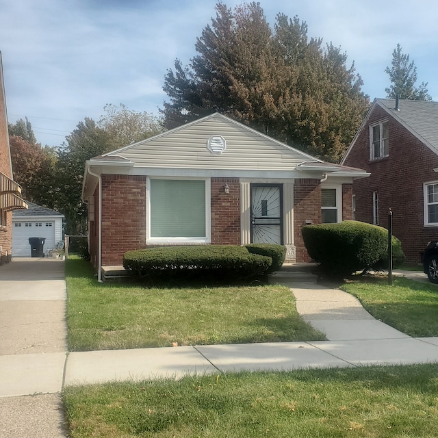 bungalow with a front lawn, an outdoor structure, and a garage