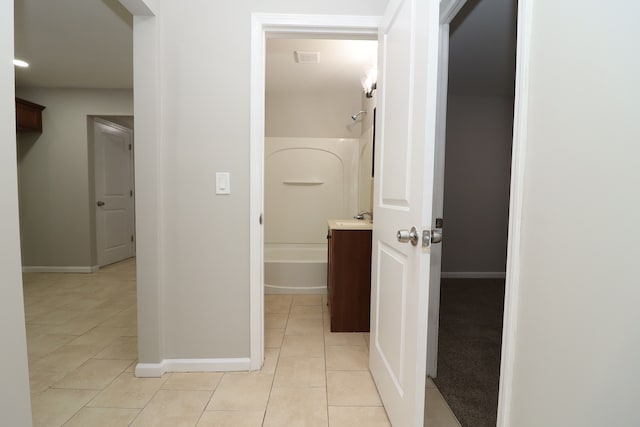 hallway featuring light tile patterned floors and sink